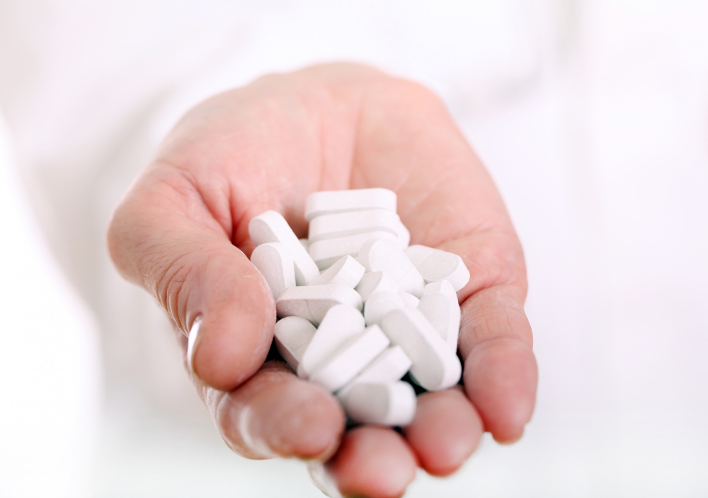 Close-up of a hand holding white pills